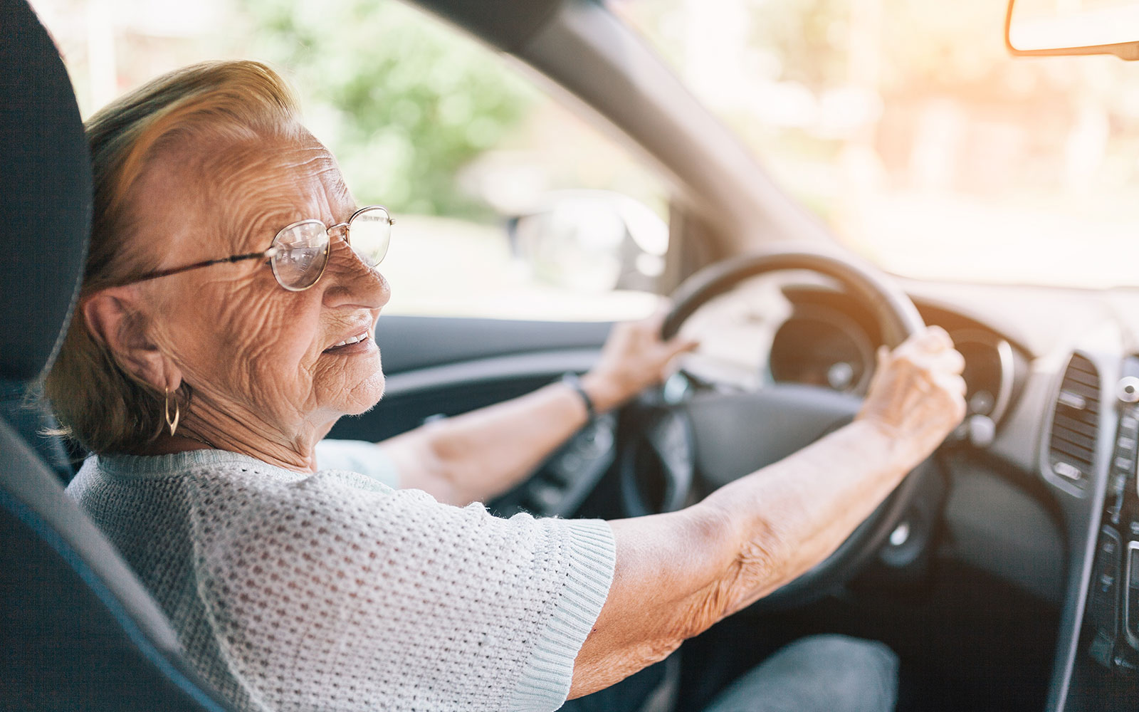 Eine alte Frau sitzt am Steuer eines Autos