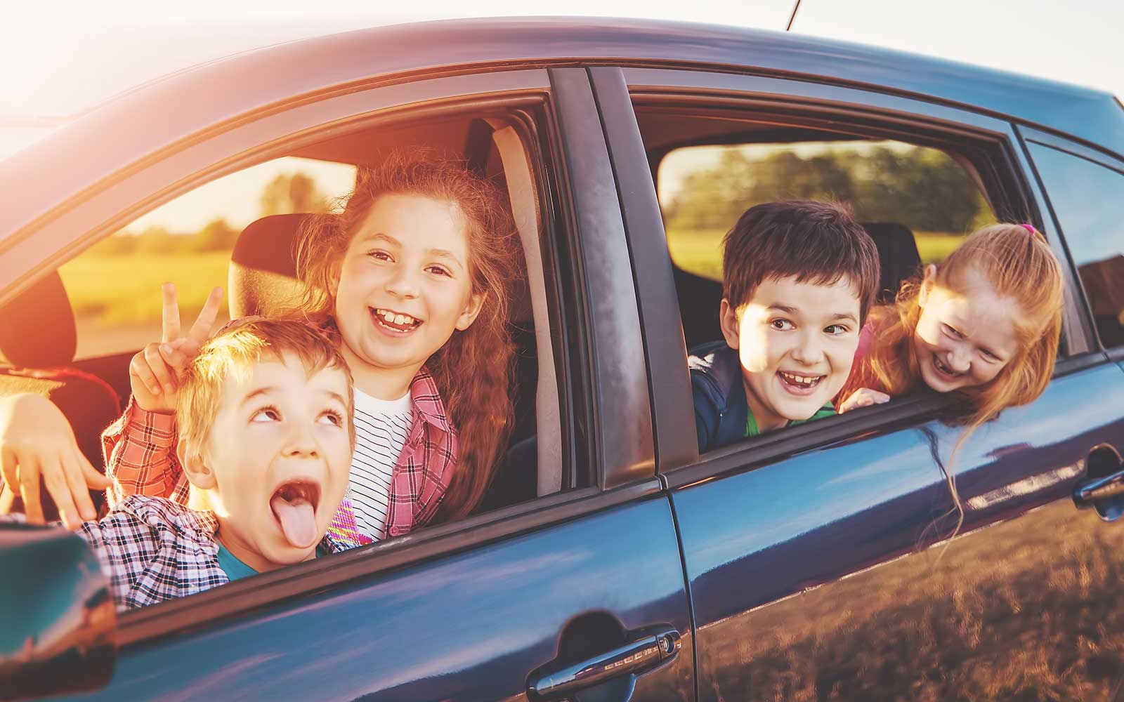 Kinder in einem stehenden Auto, die Spaß machen und nicht angegurtet sind.